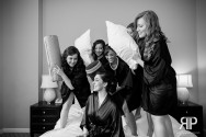 bride and her bridesmaids having a pillow fight