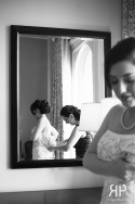 bride getting in her dress with the mirror reflection